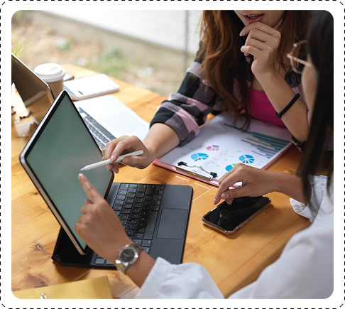 Professionals discussing data and reviewing charts on a laptop during a collaborative meeting.