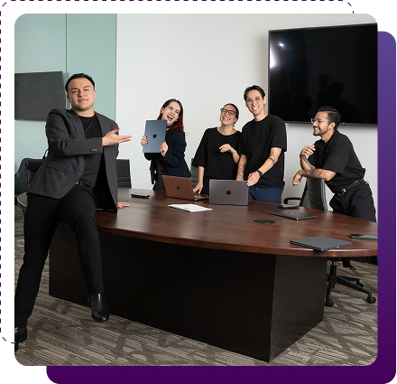 Creative team smiling and collaborating around a conference table in a modern office environment.