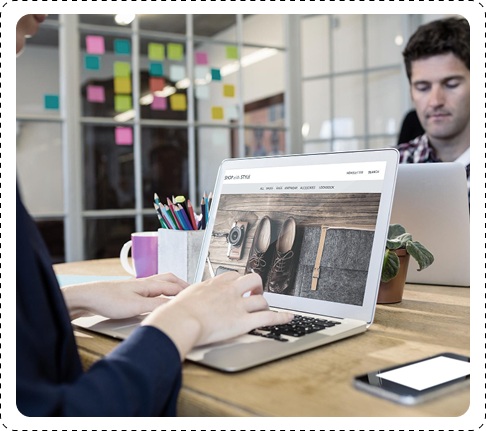 Professional reviewing a flooring website design on a laptop in a modern office workspace